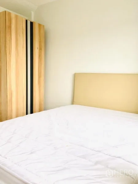 联排别墅 出租在Prawet, Bangkok - 明亮卧室，配床与木质衣柜。