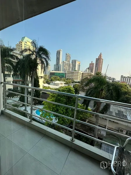 Apartment for rent in Khlong Toei, Bangkok - Balcony view over palm trees toward the Sukhumvit skyline.