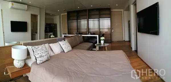 คอนโด ขายในKhlong Toei, Bangkok - ห้องนอนแบบเปิดโล่งพร้อมโซฟา ผนังกระจก พื้นไม้ และทีวี