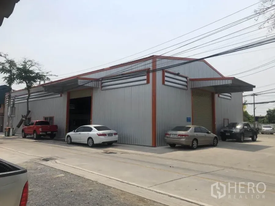 คลังสินค้า ให้เช่าในBang Yai, Nonthaburi - มุมมองด้านนอกของโกดังผนังเมทัลชีทพร้อมที่จอดรถริมถนนคอนกรีตกว้าง