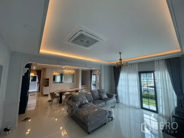 Detached House for rent in Bang Phli, Samut Prakan - Bright living room with cove lighting, sectional sofa and sliding doors to the garden.