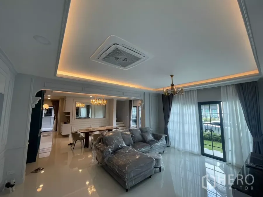 Detached House for rent in Bang Phli, Samut Prakan - Bright living room with cove lighting, sectional sofa and sliding doors to the garden.