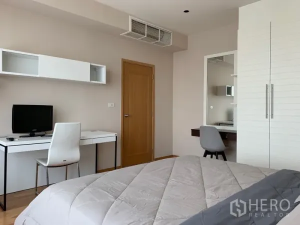 公寓 出租在Khlong Toei, Bangkok - 卧室一角，带书桌、房门和内置收纳。