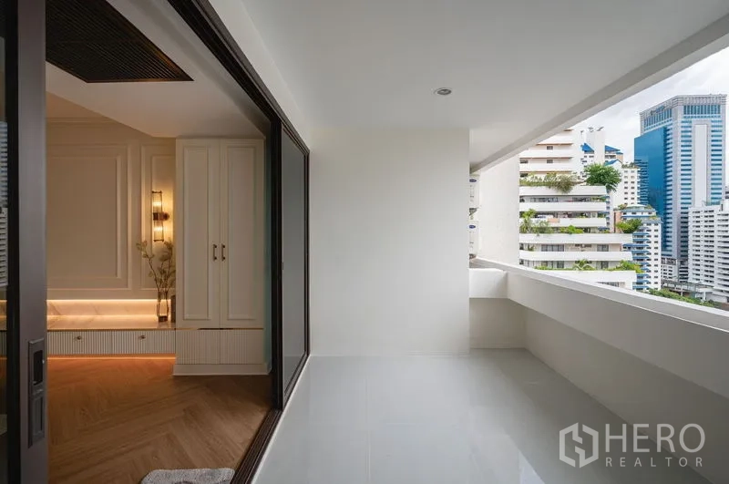 Condominium for sale in Watthana, Bangkok - Covered balcony with city views and a sliding glass door to the living area.