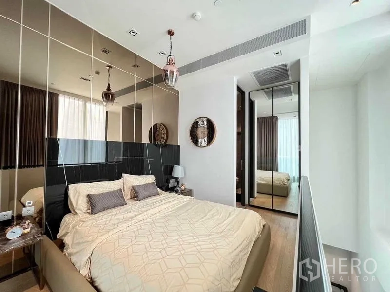 Condominium for rent - Cozy bedroom with king bed, mirrored headboard wall and pendant lights.