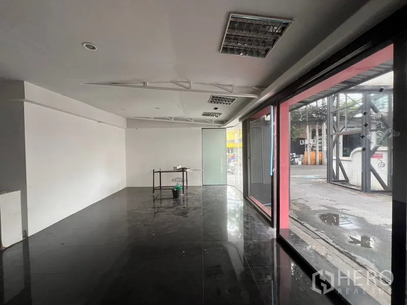 零售空间 出租在Watthana, Bangkok - 从室内望向整面落地窗，街景与人流一览无余。