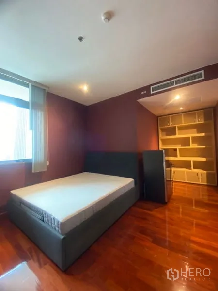 公寓 出租在Watthana, Bangkok - 客卧带内置储物柜，木地板与柔和照明。