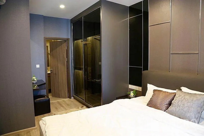 คอนโด ให้เช่าในHuai Khwang, Bangkok - ห้องนอนในคอนโดพร้อมตู้เสื้อผ้าบานกระจกบิวท์อินและประตูเข้าห้องน้ำ