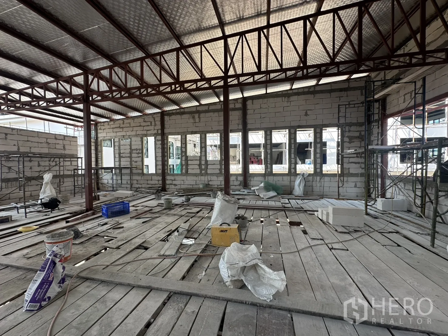 零售空间 for rent in Bang Na, Bangkok - 二层空间，保温金属屋面与钢桁架，地面堆放材料。