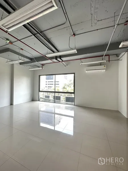 办公空间 出租在Khlong Toei, Bangkok - 明亮的办公角落，大片滑窗、壁挂空调与浅色地砖。