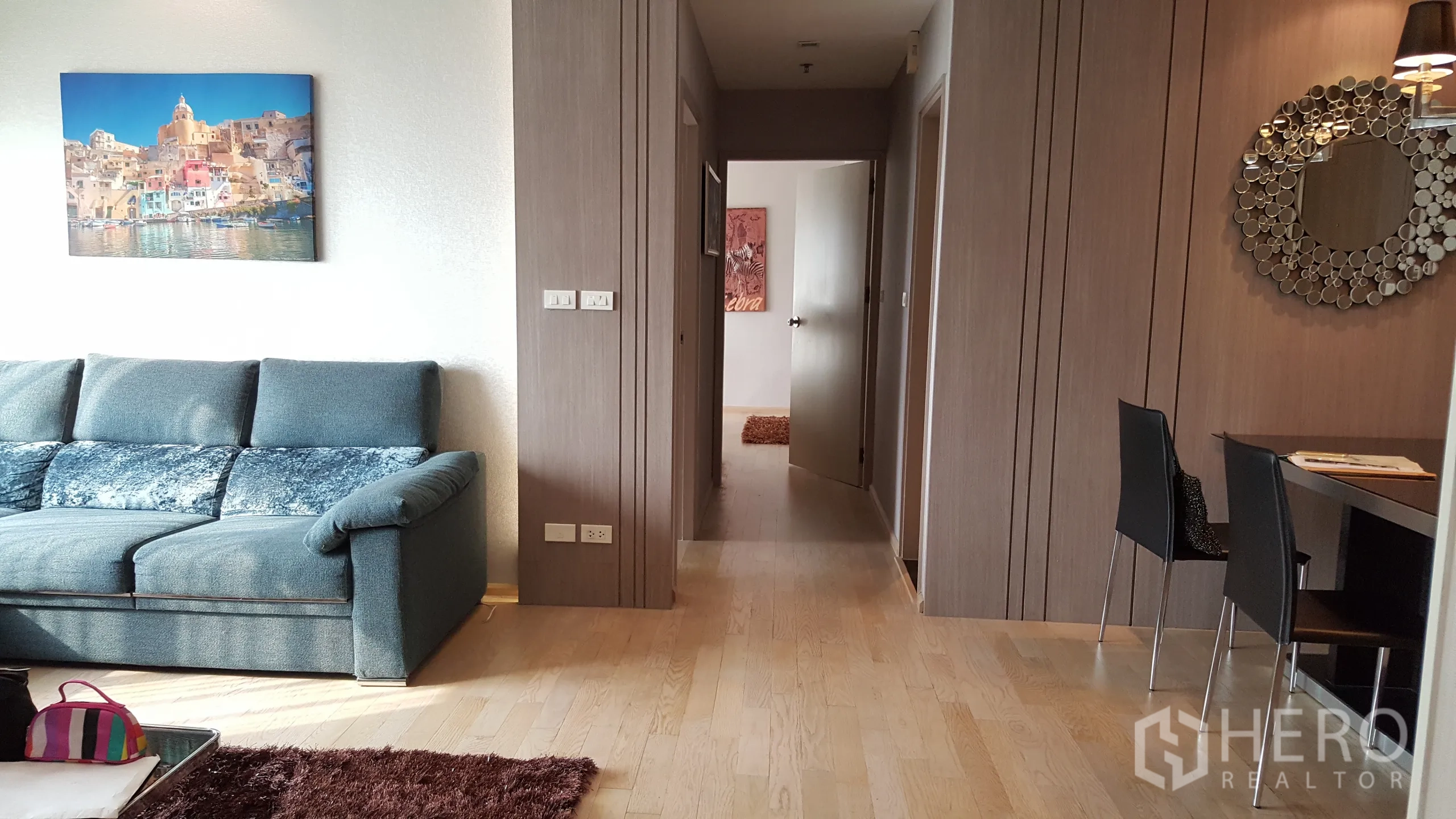 Condominium for rent in Khlong Toei, Bangkok - Hallway off the living area leading to bedrooms with warm wood flooring.