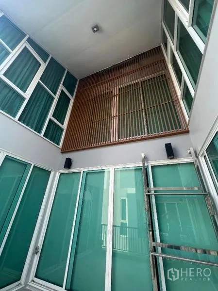 สำนักงานที่บ้าน ขายในPhra Khanong, Bangkok - ช่องแสงกลางบ้านพร้อมประตูกระจกสีเขียวและฉากระแนงไม้แนวตั้ง