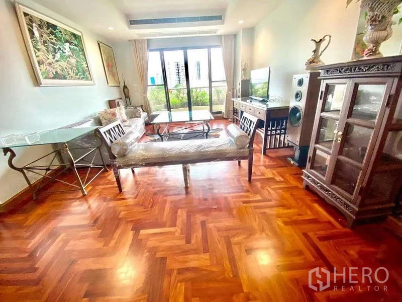 公寓 出租在Sathon, Bangkok - 客厅通向阳台的玻璃门，旁有陈列柜。