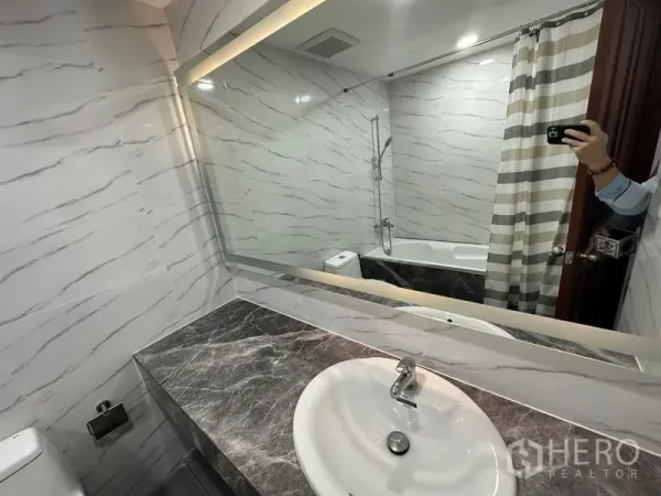 คอนโด ให้เช่าในWatthana, Bangkok - มุมมองห้องน้ำ มีอ่างล้างหน้าเคาน์เตอร์หินอ่อน ผ้าม่านอาบน้ำลายทาง และกระจกเต็มผนัง