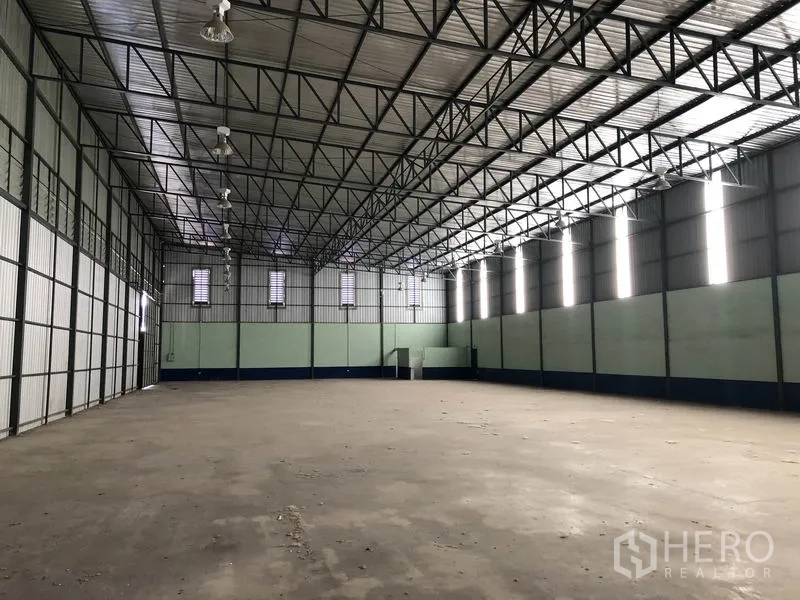 货栈 出租在Pathum Thani - 仓库内部空间开阔，钢结构高屋顶与混凝土地面清晰可见。