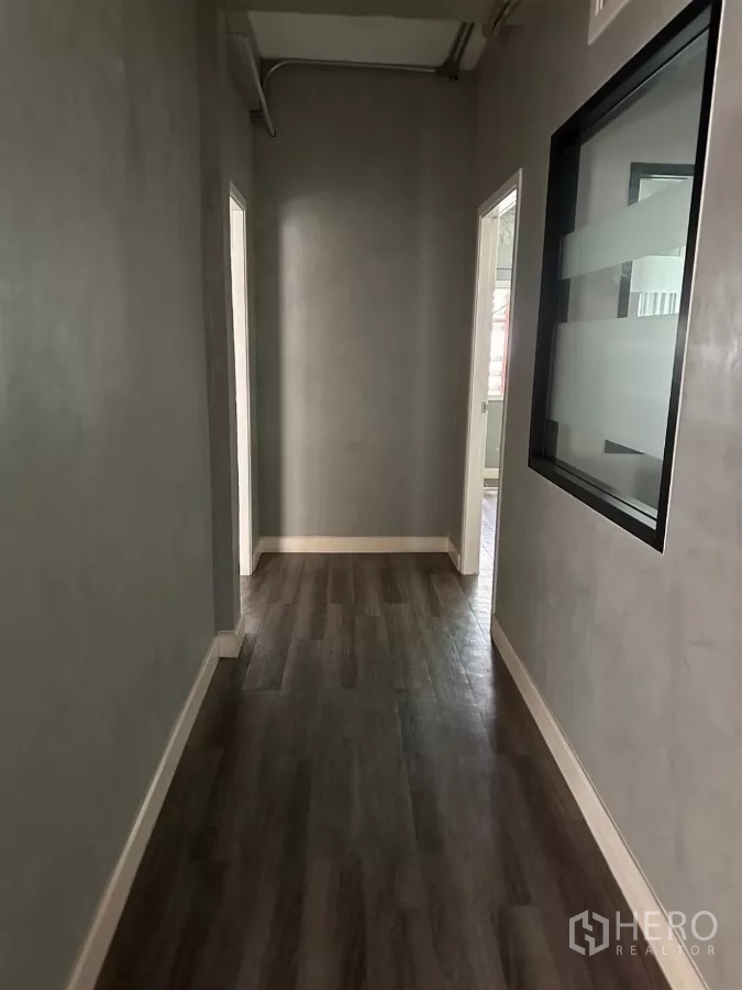 อาคารพาณิชย์ ขายในWatthana, Bangkok - ทางเดินผนังเทา มีช่องหน้าต่างกระจกภายในและประตูสู่สำนักงานย่อย.