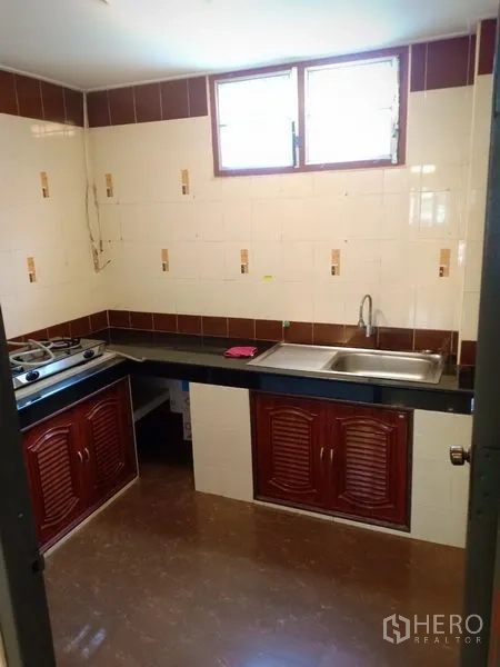 ทาวน์เฮาส์ ให้เช่าในPhra Khanong, Bangkok - ครัวแบบไทยมีหน้าต่าง ผนังกระเบื้อง เคาน์เตอร์ยาว ซิงก์ และเตาแก๊ส