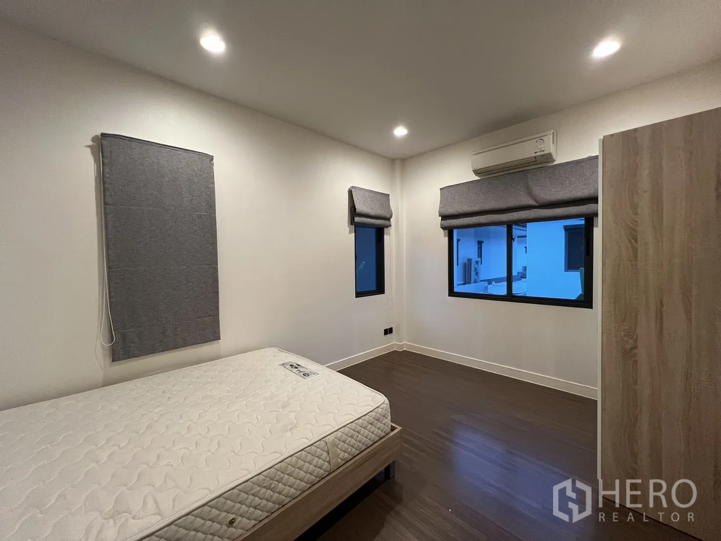 บ้าน ให้เช่าหรือขายในBang Kapi, Bangkok - ห้องนอนมีหน้าต่างคู่ เตียง และพื้นไม้