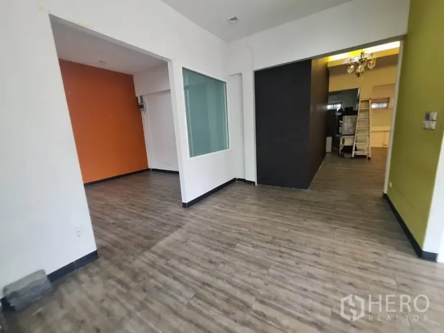 零售空间 出租在Watthana, Bangkok - 开放式室内空间，木纹地板、白色墙面与玻璃隔断。