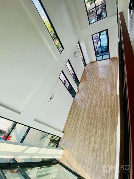 Home Office for sale in Wang Thonglang, Bangkok - Top view of a long open hall with wood flooring and multiple glass doors.