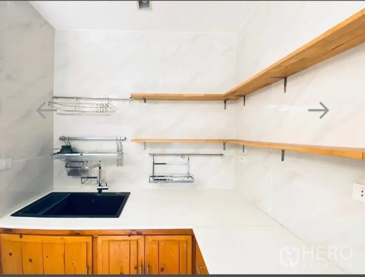 Detached House for sale in Saphan Sung, Bangkok - Kitchen sink corner with open shelves and wall-mounted storage racks.