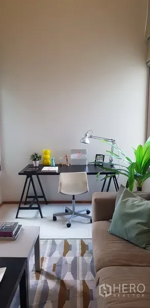 公寓 出租在Khlong Toei, Bangkok - 居家办公角，靠近沙发，配台灯与绿植。