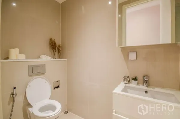 คอนโด ให้เช่าหรือขายในWatthana, Bangkok - ห้องน้ำมินิมอลพร้อมโถสุขภัณฑ์แขวนผนัง อ่างล้างหน้า และกระเบื้องโทนกลาง