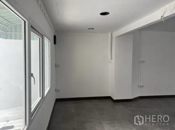 零售空间 出租在Khlong Toei, Bangkok - 明亮内角，白墙、大窗与灰色地砖。