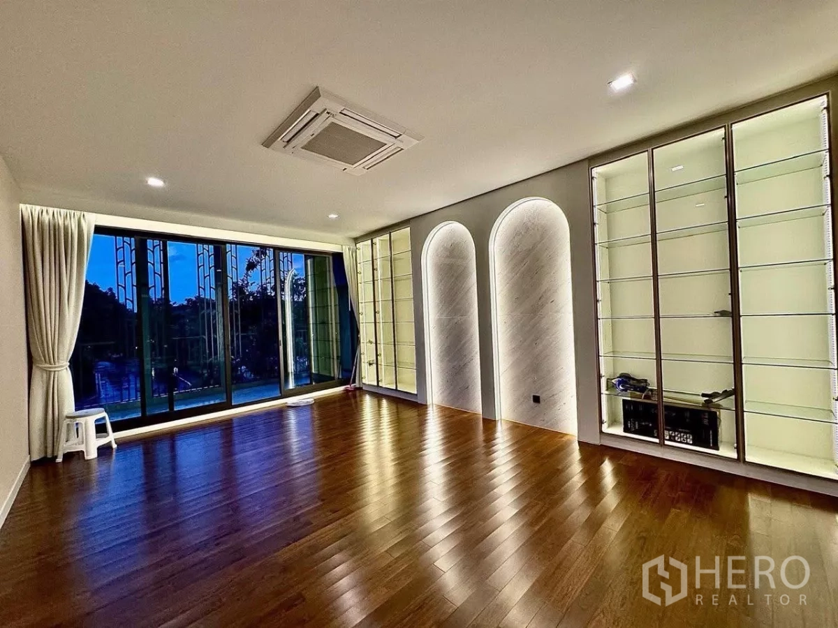 Detached House for sale in Saphan Sung, Bangkok - Open studio room with illuminated display cabinets and wide balcony doors.