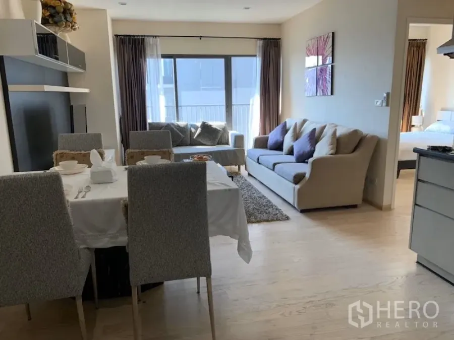 คอนโด ให้เช่าในKhlong Toei, Bangkok - พื้นที่นั่งเล่นและรับประทานอาหารแบบเปิดโล่ง โต๊ะอาหารสี่ที่นั่ง โซฟา และประตูระเบียงรับแสงธรรมชาติ