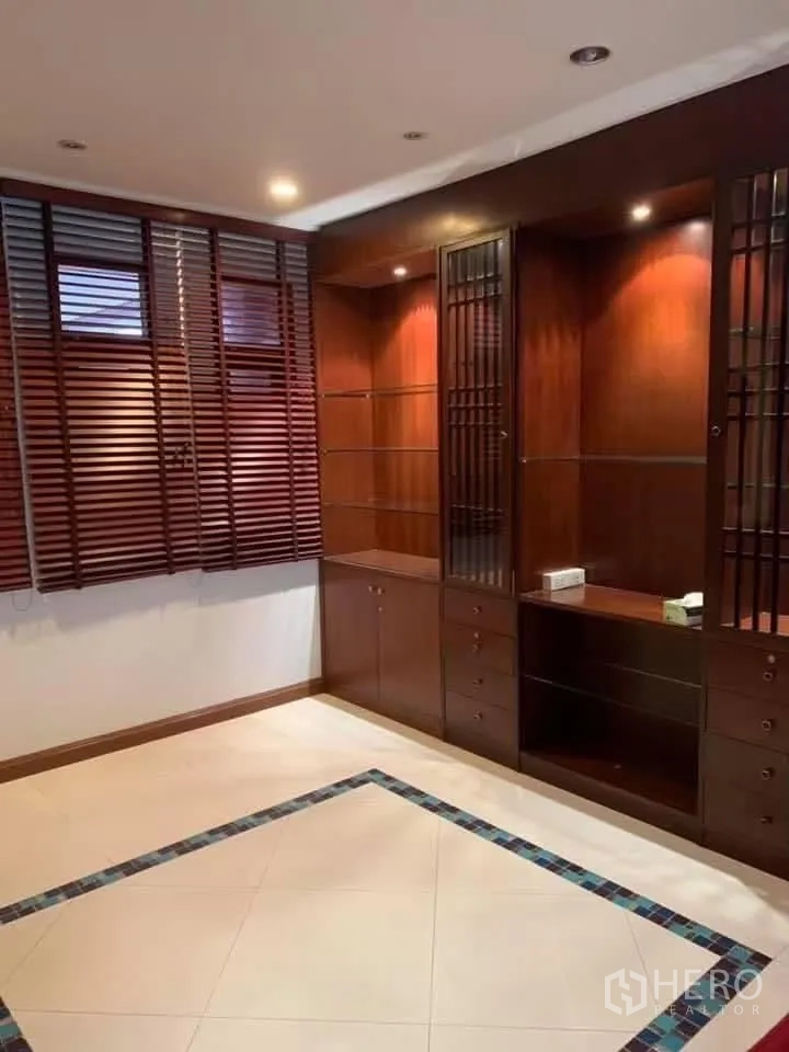 Townhouse for rent in Watthana, Bangkok - Room with built-in wooden cabinetry, recessed lighting, and tiled floor.