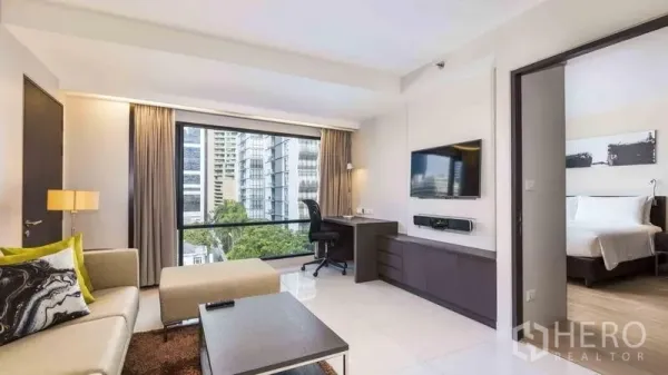 Apartment for rent in Watthana, Bangkok - Bright living room with sofa, work desk, TV unit and large window offering city views.