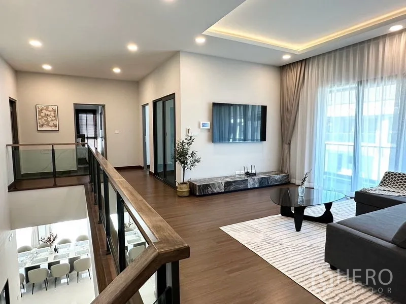 Detached House for rent or sale in Bang Phli, Samut Prakan - Upstairs family area with wall-mounted TV and balcony access.