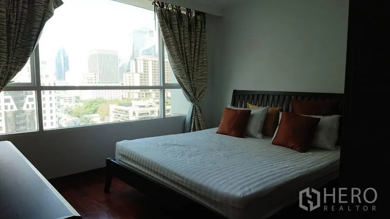 Condominium for rent in Pathum Wan, Bangkok - Bedroom with king bed and a wide picture window showcasing Bangkok skyline views.