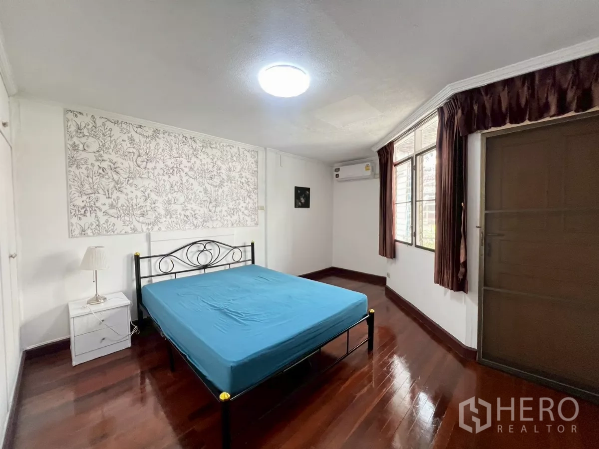 Home Office for rent in Watthana, Bangkok - Bright bedroom with wood floors, metal bed and large window.