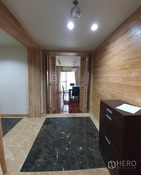 คอนโด ให้เช่าในWatthana, Bangkok - โถงทางเข้าผนังไม้ ประตูบานคู่ลาย格ไม้ เปิดสู่พื้นที่รับประทานอาหาร