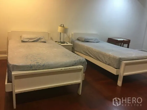 คอนโด ให้เช่าในWatthana, Bangkok - ห้องนอนมีเตียงเดี่ยวคู่ โต๊ะหัวเตียง แสงไฟอบอุ่น และพื้นไม้ขัดเงา