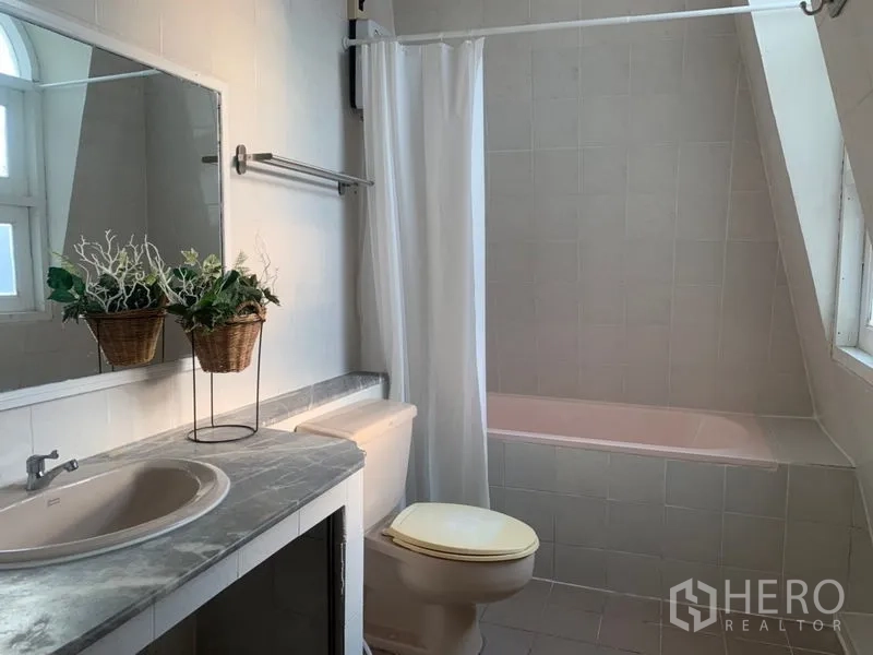 Home Office for rent in Suan Luang, Bangkok - Light-toned bathroom with bathtub, large mirror and countertop basin.