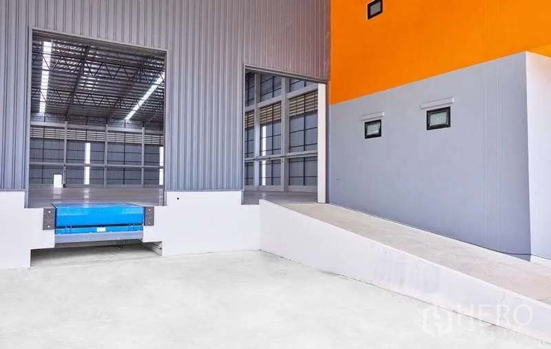 Factory for rent in Bang Phli, Samut Prakan - Truck ramp and dock area beside gray metal cladding and office facade