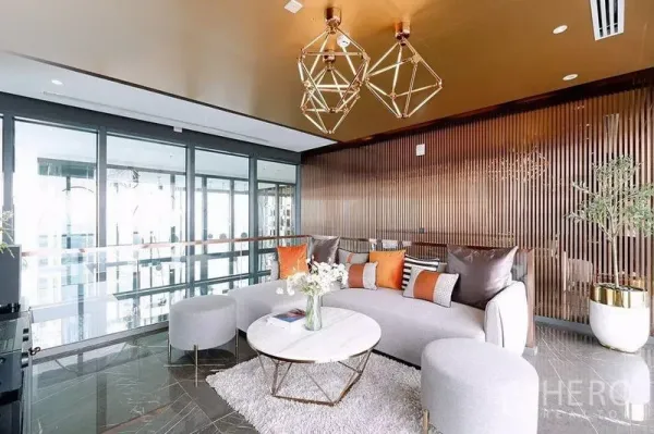 公寓 出租在Watthana, Bangkok - 时尚会所，金色几何吊灯、弧形沙发与落地窗。
