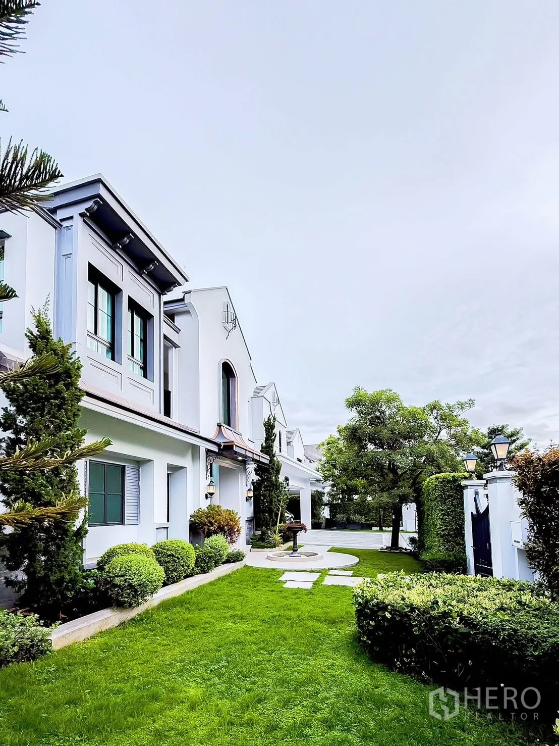 Detached House for rent in Saphan Sung, Bangkok - Side garden with manicured lawn, shrubs and pathway beside the house.