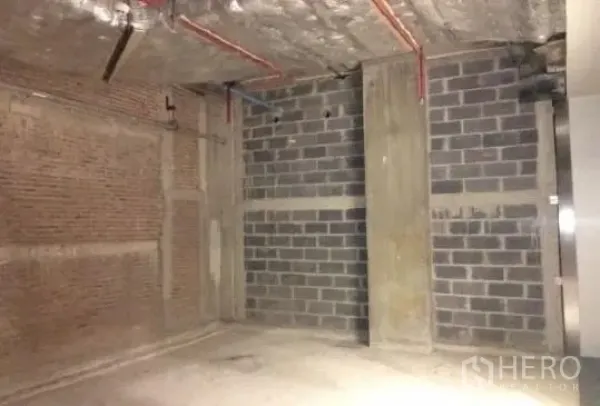 零售空间 出租 - 76平米毛坯零售单元，外露混凝土顶与砖块墙体，可见红色管线。