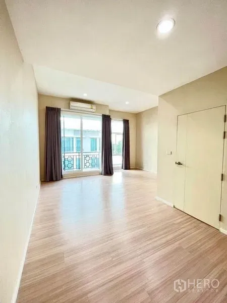 ทาวน์เฮาส์ ขายในBang Kapi, Bangkok - ห้องโปร่งชั้นบน พื้นไม้ลามิเนต ประตูกระจกบานเลื่อนออกระเบียง พร้อมเครื่องปรับอากาศและผ้าม่านทึบ