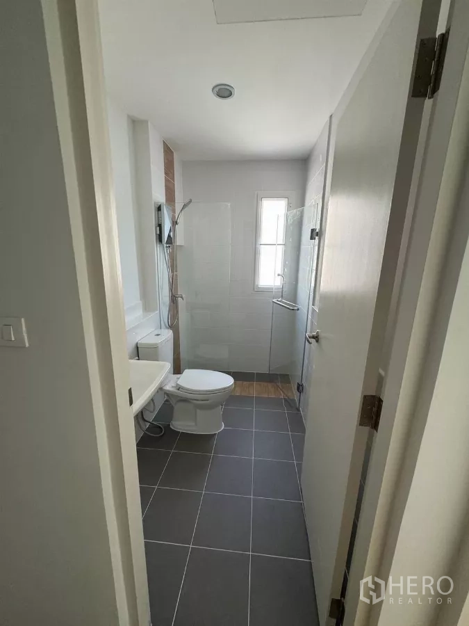 Detached House for rent in Bang Phli, Samut Prakan - Upper-floor bathroom with walk-in shower, white wall tiles and window ventilation.