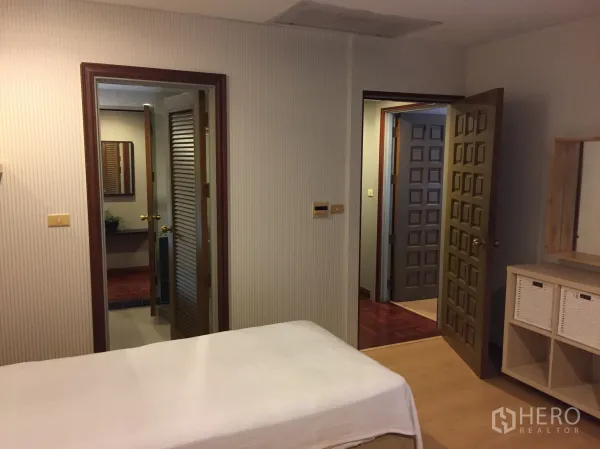 คอนโด ให้เช่าในPathum Wan, Bangkok - มุมมองอีกด้านของห้องนอนเตียงคู่ เห็นประตูห้องน้ำและโต๊ะเครื่องแป้ง