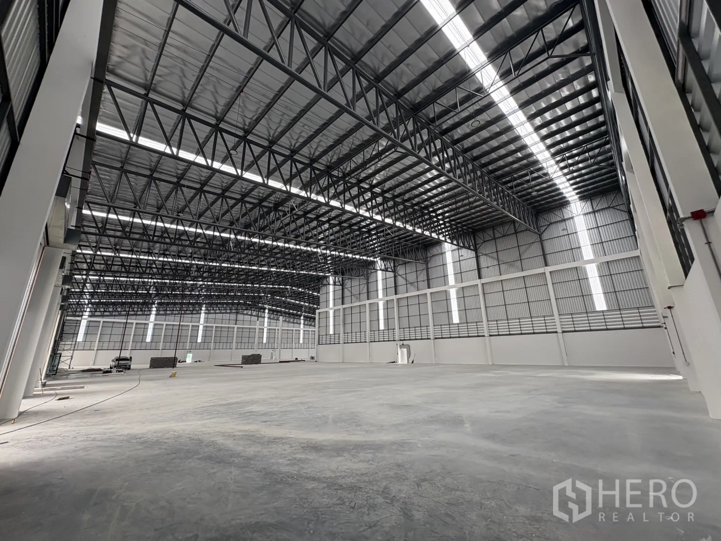 Factory for rent in Bang Pakong, Chachoengsao - Expansive production hall with high roof and bright natural light strips.