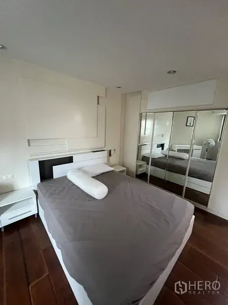 คอนโด ให้เช่า - ห้องนอนมาสเตอร์พื้นไม้ โทนสีขาว พร้อมตู้เสื้อผ้าบานกระจก