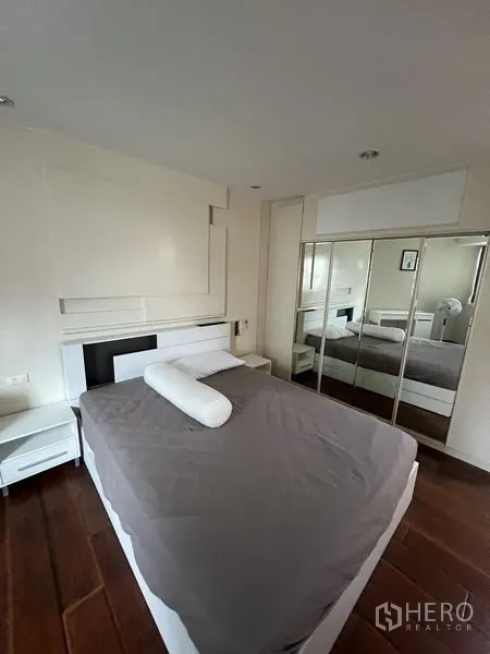 คอนโด ให้เช่า - ห้องนอนมาสเตอร์พื้นไม้ โทนสีขาว พร้อมตู้เสื้อผ้าบานกระจก