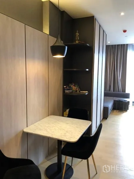 คอนโด ให้เช่าในDin Daeng, Bangkok - มุมรับประทานอาหารขนาดกะทัดรัด โต๊ะหินอ่อน โคมไฟแขวน และชั้นบิลท์อินข้างผนังไม้