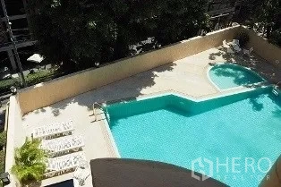 Condominium for rent in Pathum Wan, Bangkok - Outdoor swimming pool with sun loungers viewed from an upper floor.